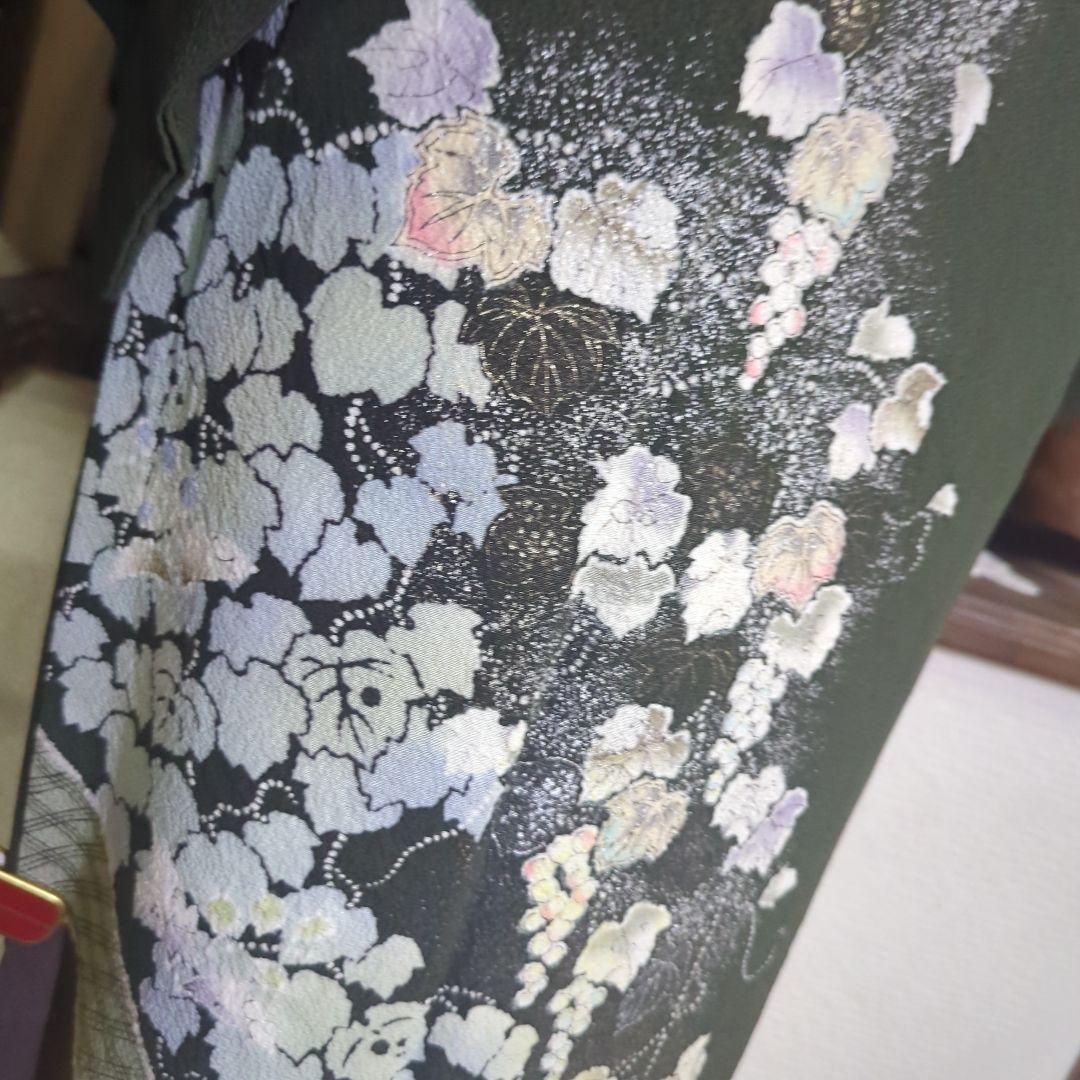 落款が入ります、青丹色の地に煌めく葡萄柄が繊細な美しさを見せる正絹訪問着です