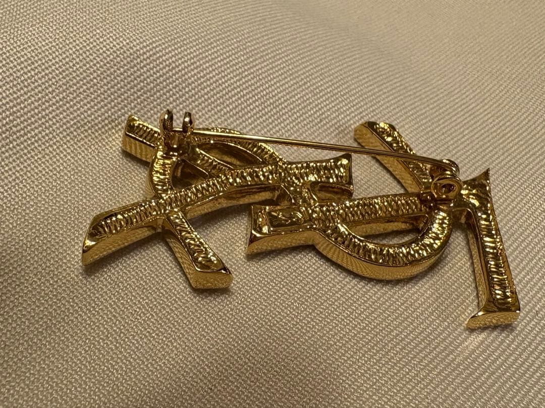 イブ・サンローラン ロゴ ブローチ ピンの留め具が外れてます。